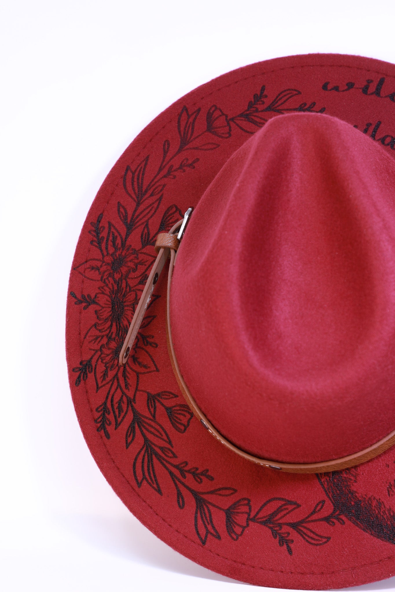 Top-down view of the hat showing both the horse and wildflower engravings together