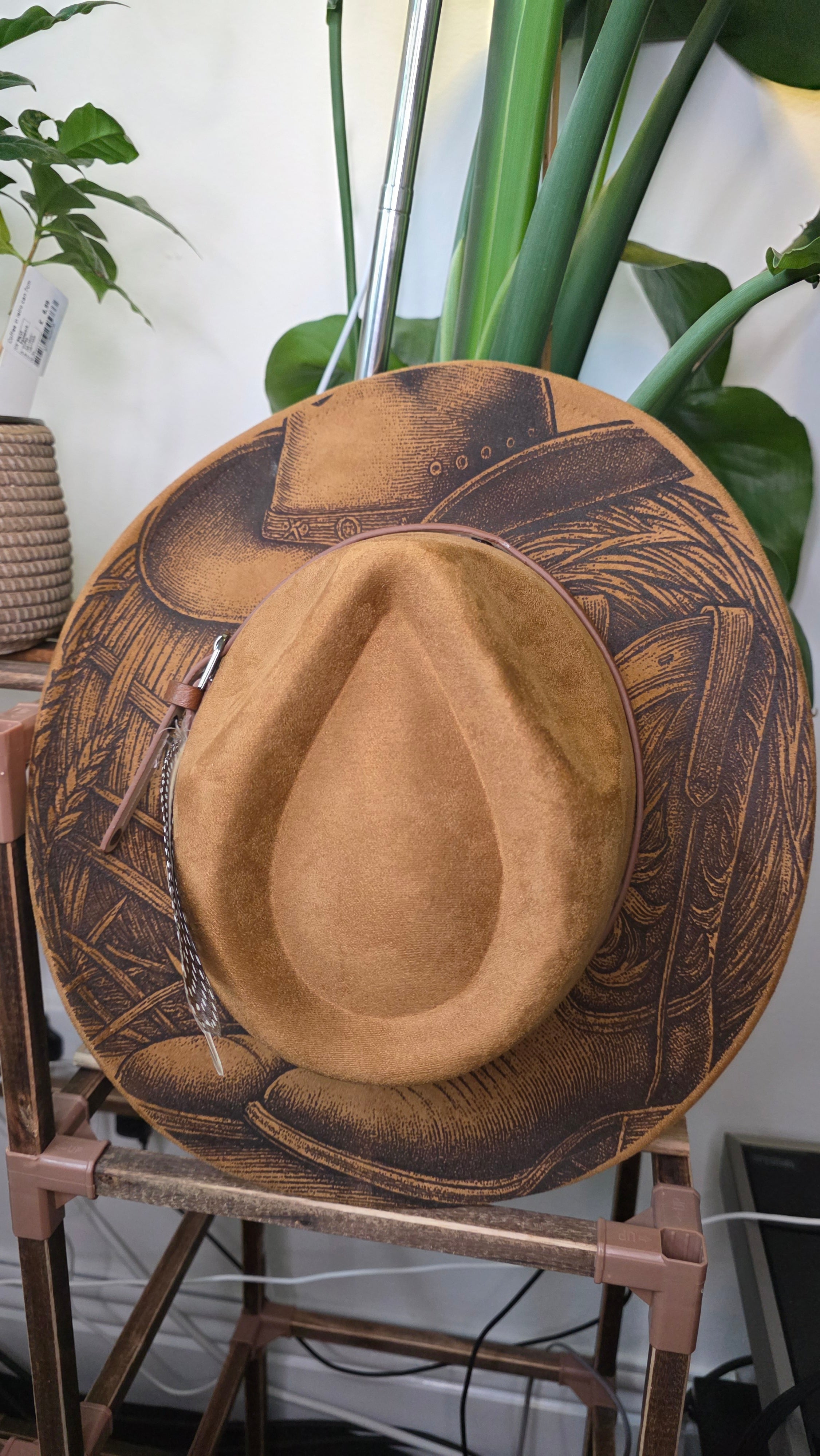 Hat engraved with cowboy hat on top of cowboy boots
