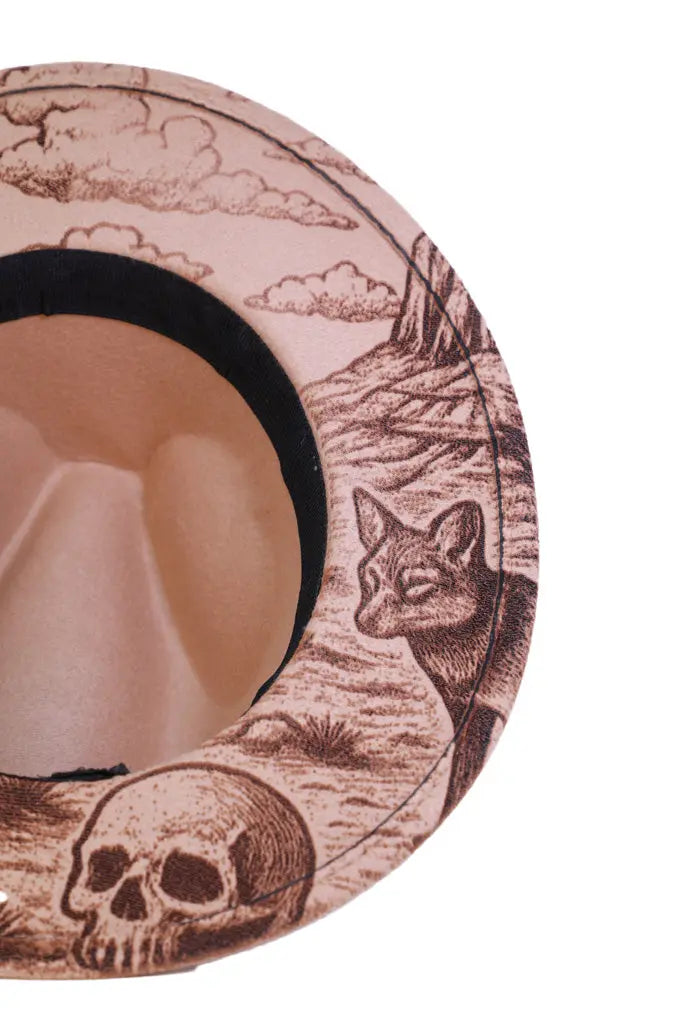 Close-up of engraved coyote and skull details on hat brim