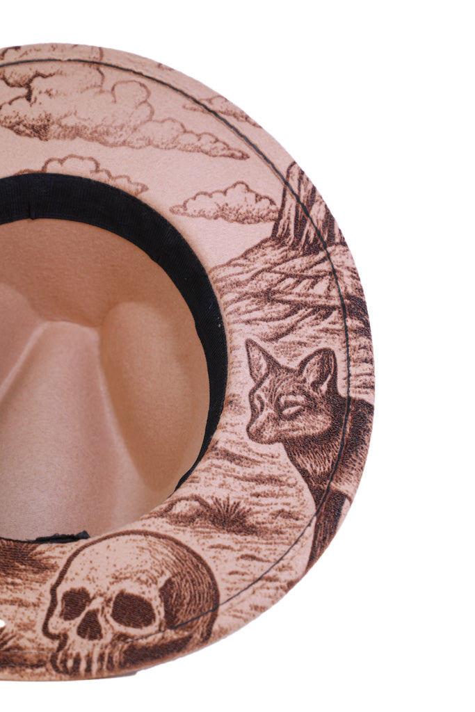 Close-up of engraved coyote and skull details on hat brim