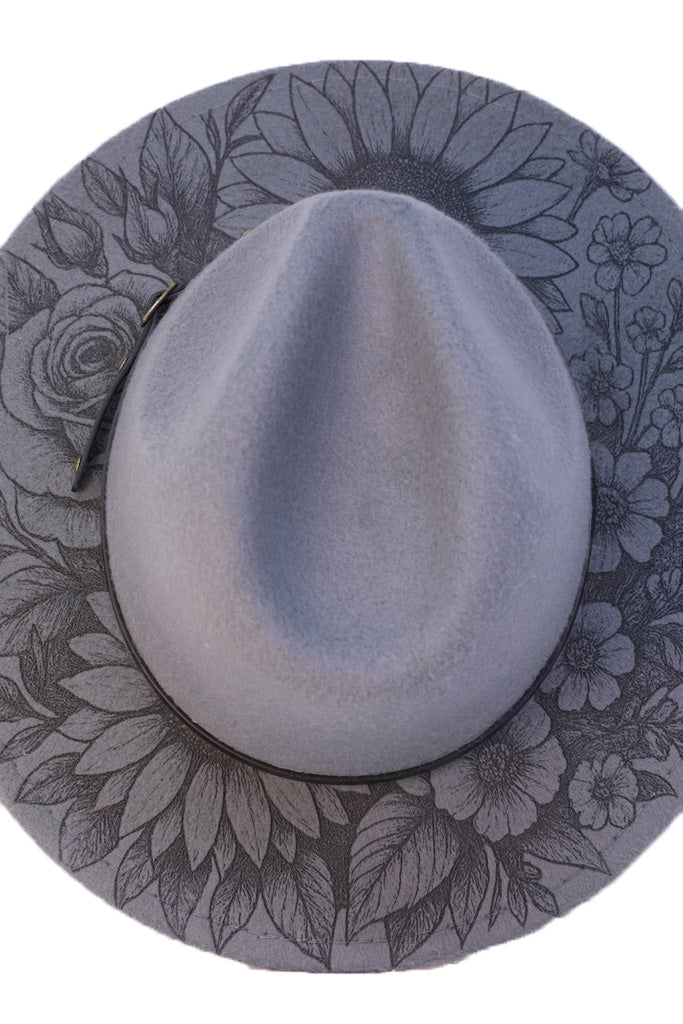 Close-up of laser-engraved sunflower and rose on grey hat