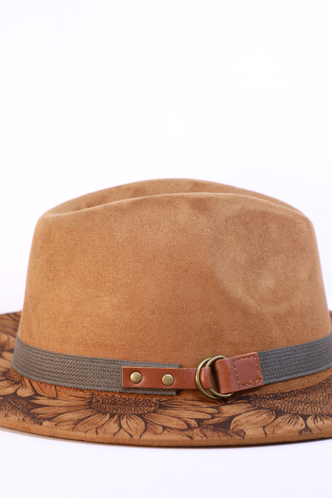 Detail view of laser engraved design on the brim of a suede polyester fedora hat.