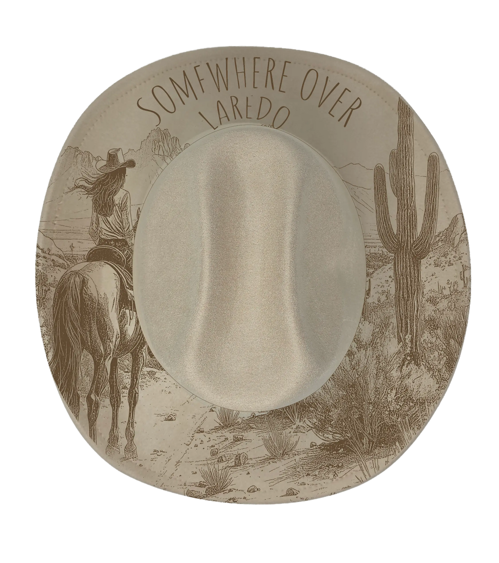 Biege cattleman hat with somewhere over Laredo and cowgirl on horse desert scene engraving